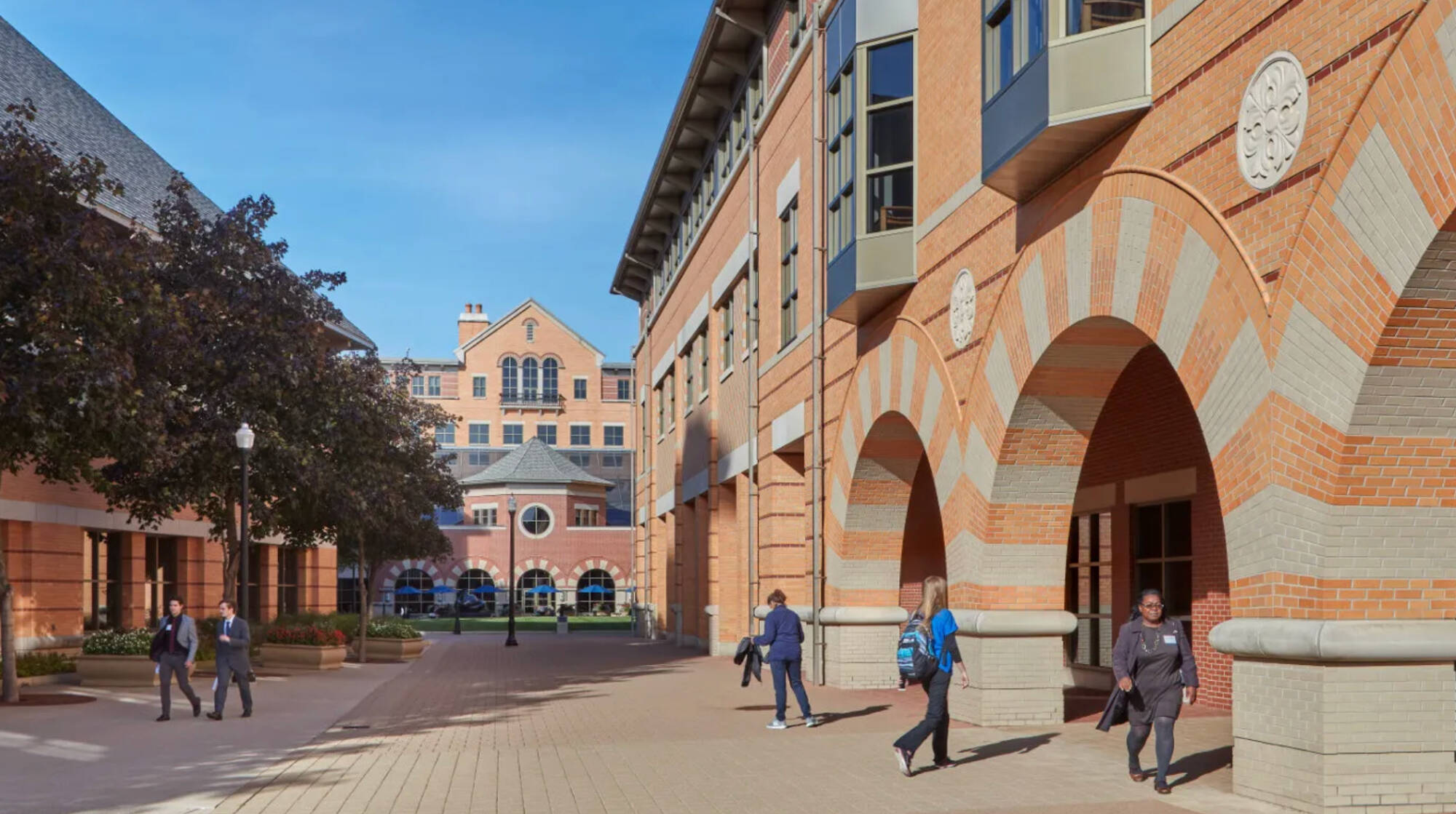 students walking across pew campus outside devos building